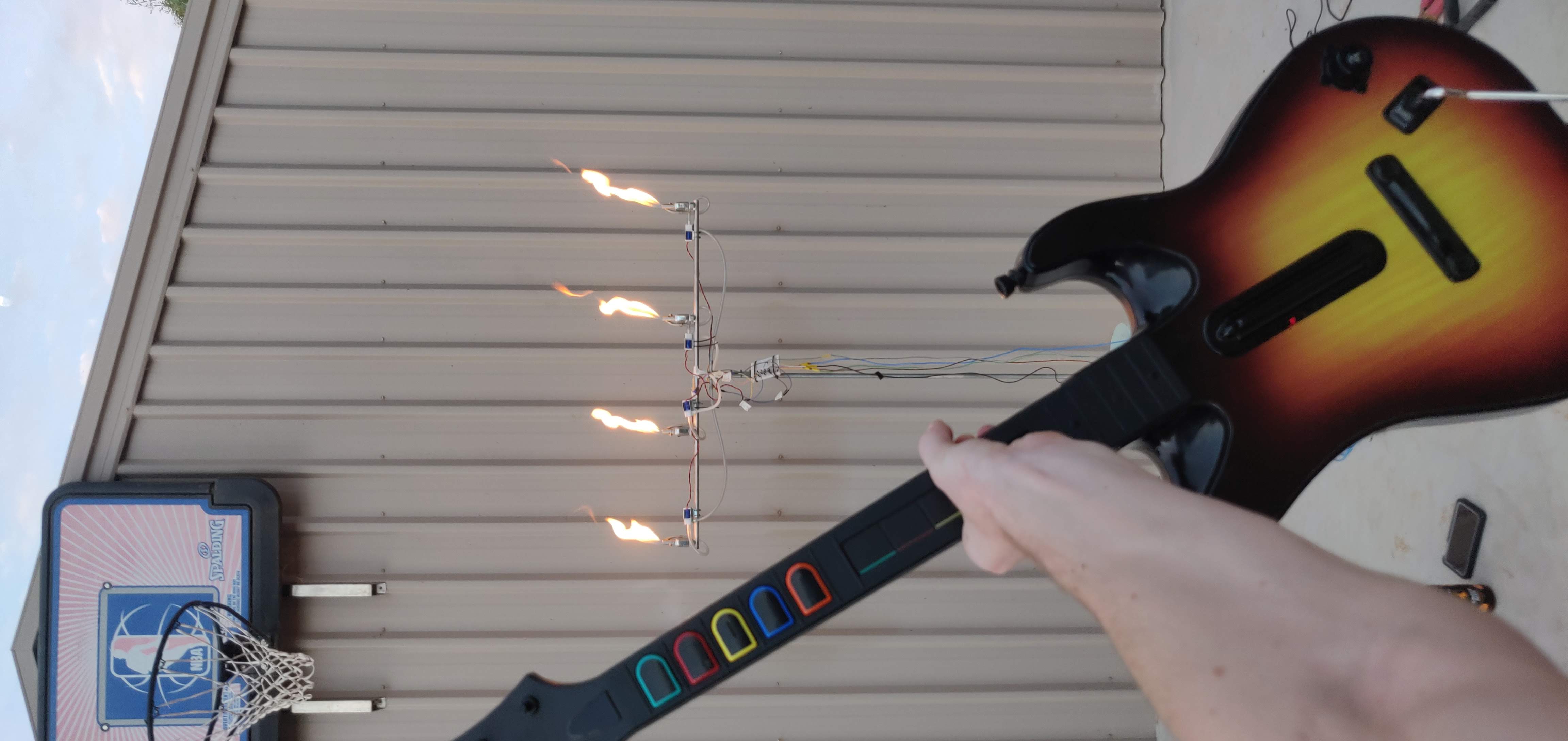 holding Guitar Hero Guitar in front of flamethrower